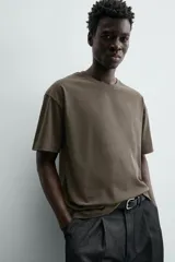 Camiseta color arena de algodón compacto, corte recto, cuello redondo y mangas cortas.