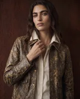 Jacket de cuero color camel con acabado envejecido, diseño estructurado con solapas, cierre frontal con broches a presión y bolsillos frontales con solapa.