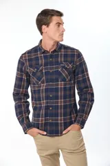 Sobrecamisa de estilo leñador con estampado de cuadros, confeccionada en tela de viyela. Presenta cuello clásico, cierre frontal con botones y dos bolsillos con solapa en el pecho.