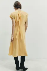 Vestido midi de corte evasé confeccionado en mezcla de modal, con cuello fluido tipo drapeado, manga sisa caída y abertura en la espalda.