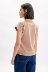 Remera de manga corta con efecto lavado acid wash en color beige, con cuello redondo en rib y mangas con dobladillo estructurado.