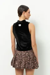 Top de terciopelo marrón, sin mangas y de cuello alto.