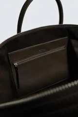 Bolso shopper de cuero vacuno con acabado abatanado, diseño minimalista con cierre de cremallera superior, doble asa de mano y detalle de llavero colgante. El interior incluye un bolsillo plano y un bolsillo con cierre.