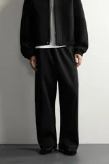 Pantalón de corte relajado confeccionado en tejido de algodón, con cintura elástica y detalle de pliegues estructurales en las perneras. Cuenta con bolsillos frontales y un bolsillo trasero de plastrón.