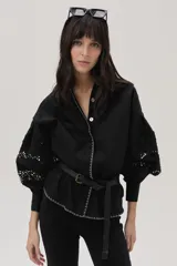 Camisa negra de popelina con calce recto y mangas abullonadas con detalles de encaje floral. Incluye cinturón fino con hebilla metálica.