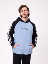 Canguro con capucha de estilo deportivo, con cuerpo en color celeste y mangas raglán en color negro. Presenta el logo de la marca estampado en el pecho, bolsillo tipo canguro frontal y franjas blancas laterales en las mangas.