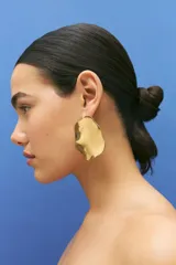 Aros colgantes de acero inoxidable color dorado con forma irregular.