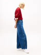 Jean de corte globo y talle alto, confeccionado en tejido denim rígido de color azul. Presenta diseño de cinco bolsillos, cierre de cremallera con botón y efecto desteñido en muslos y cadera.