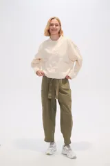 Chaqueta color crema de algodón con cuello mao, cierre frontal con botones, bolsillos laterales y mangas largas.