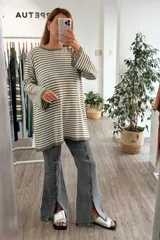 Vestido tejido de punto con diseño a rayas horizontales en color verde y blanco, de corte holgado, manga larga y cuello redondo.