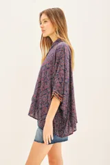 Camisa de algodón con estampado floral en tonos azul y rojo, corte amplio y mangas 3/4 con detalle bordado en los puños.