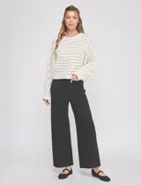 Pantalón wide leg negro de tiro alto, con pretina con pasadores, botón y cierre. Incluye bolsillos en la parte delantera y trasera.