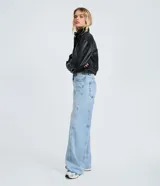 Pantalón wide leg de denim de algodón, con cintura media, cierre frontal con botón y cremallera, bolsillos funcionales y detalle de recortes transversales en las piernas.