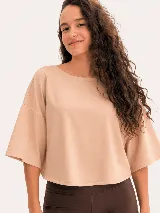 Remera de algodón con diseño de espalda abierta y detalle de nudo torzado. Presenta un corte holgado y mangas cortas, ideal para actividades deportivas o uso casual.