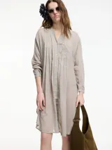 Túnica blanca de algodón con cuello mao, botones frontales y tajos laterales.