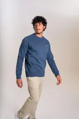 Buzo de cuello redondo en color azul, con diseño liso y logo bordado pequeño en el pecho. Presenta puños y ruedo acanalados.