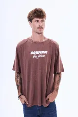 Remera de algodón con efecto lavado, color marrón, de corte oversize, cuello redondo y manga corta. Presenta una estampa frontal con el texto 'CONFIRM the future' en color blanco.