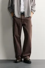 Pantalón jeans de corte relaxed fit, color celeste con efecto lavado, de estilo carpintero con bolsillos laterales y presillas de herramientas.