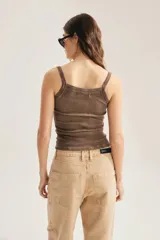 Musculosa de punto canalé color marrón, con breteles finos, escote recto y detalle de aplicación de tachas brillantes en toda la superficie. Diseño ajustado al cuerpo.