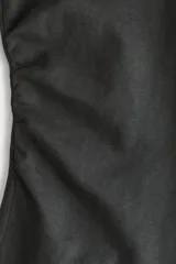 Top de manga larga confeccionado en punto de algodón, con cuello redondo, hombros caídos y detalle de frunces laterales que generan un bajo acampanado.