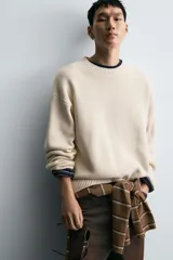 Jersey de corte relajado confeccionado en tejido de algodón. Presenta cuello redondo, manga larga y acabados en rib en puños, cuello y bajo.