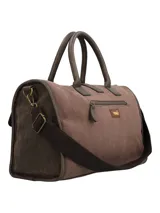 Cartera de mano marrón de estilo bohemio con detalles en tela étnica tipo tapicería bajo los bolsillos frontales con solapa. Cuenta con doble asa fija, correa ajustable y desmontable, cierre superior y llavero colgante con borla y cuentas decorativas.
