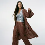 Pantalón de tiro alto color marrón con estampado floral, corte recto y lazo ajustable en la cintura.