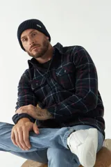 Sobrecamisa polar a cuadros azul marino, con bolsillos tipo cartera y laterales, logo en grifa de goma y fit regular.