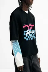 Remera de malla negra con cuello en V, mangas cortas y hombros caídos. Presenta un estampado frontal con la frase "THUNDER X RACING TEAM" y un diseño gráfico en tonos rosa, azul y celeste con la palabra "RACING" y un patrón de cuadros.