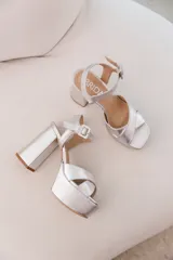 Sandalias plateadas de fiesta con tiras cruzadas en el empeine, plataforma delantera y tacón cuadrado alto.