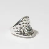Anillo plateado con textura irregular.