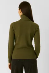 Polera de tejido de punto color blanco, con cuello redondo y manga larga.