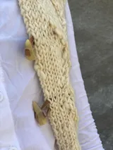 Chaleco tejido en lana merino con diseño de rombos en relieve, cierre frontal con botones de guampa y detalles en cuero.