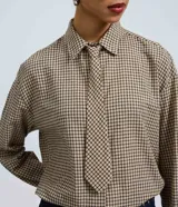 Camisa oversized de algodón con estampado de cuadros, cuello camisero clásico, mangas largas y corbata confeccionada en el mismo tejido.