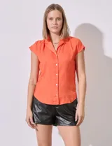 Camisa naranja de satén marca Philosophy, con cuello con solapa y abertura central con botones.