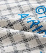 Camisa de manga corta para hombre con diseño boxy, confeccionada en tricolina de algodón con estampado de cuadros y textura sutil. Presenta cuello camisero, cierre frontal con botones y un bolsillo aplicado en el pecho.