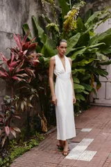 Vestido midi de algodón con diseño de bordado inglés perforado. Presenta escote en pico, diseño sin mangas y tirantes cruzados en la espalda con detalle de argolla.
