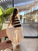 Musculosa de punto tejida en hilo de algodón, con diseño a rayas horizontales en color negro y crudo, escote halter con tirantes ajustables para atar al cuello.