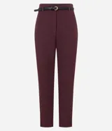 Pantalón de vestir color bordó, corte carrot de sastrería, tiro alto, con pliegues frontales y bolsillos falsos traseros. Incluye un cinturón fino negro con hebilla dorada en forma de símbolo de euro.