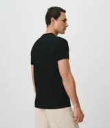 Remera slim de hombre en color blanco, con cuello redondo, mangas cortas y textura acanalada de rayas verticales.