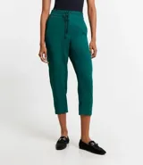 Pantalón de vestir femenino color marrón oscuro, de corte fluido y tiro medio/alto, con cintura elástica ajustable mediante cordón. Presenta bolsillos laterales y cierre frontal.