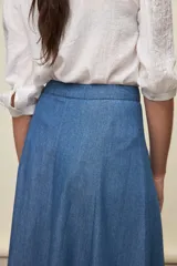 Falda larga de denim azul, con tiro alto y silueta amplia de corte midi y caída fluida.