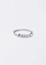 Anillo fino de plata 925 con diseño central compuesto por tres pequeñas piedras circulares tipo punto de luz y dos detalles laterales en forma de rombo con incrustaciones de zirconia.