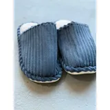Pantuflas de pana azul con textura acanalada, diseño sin talón y borde trenzado decorativo. Cuentan con interior suave y suela de EVA.