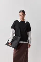 Remera de manga corta negra de algodón, con silueta relajada, cuello redondo y tajos laterales.