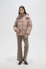 Campera puffer de corte holgado, color beige, con capucha desmontable, cierre frontal y puños elásticos.