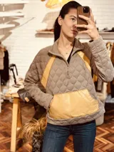 Sweater gris con diseño acolchado, cuello alto con cierre parcial y detalles en cuero amarillo bordado a mano en laterales y bolsillo frontal.