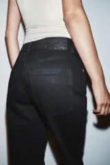 Jeans de tiro alto, pernera recta y larga, estilo clásico con cinco bolsillos, cierre frontal con cremallera y botón metálico.