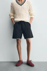 Bermuda de algodón rizo (tipo toalla) color azul marino, de corte regular fit. Presenta cintura elástica con cordón interno ajustable, bolsillos frontales y un bolsillo trasero de plastrón. Los bordes tienen un ribete blanco a contraste.