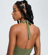 Vestido sin mangas, color marrón oscuro, con escote tipo halter y lazo en el cuello. El tejido es de malla con efecto tricot texturizado acanalado.